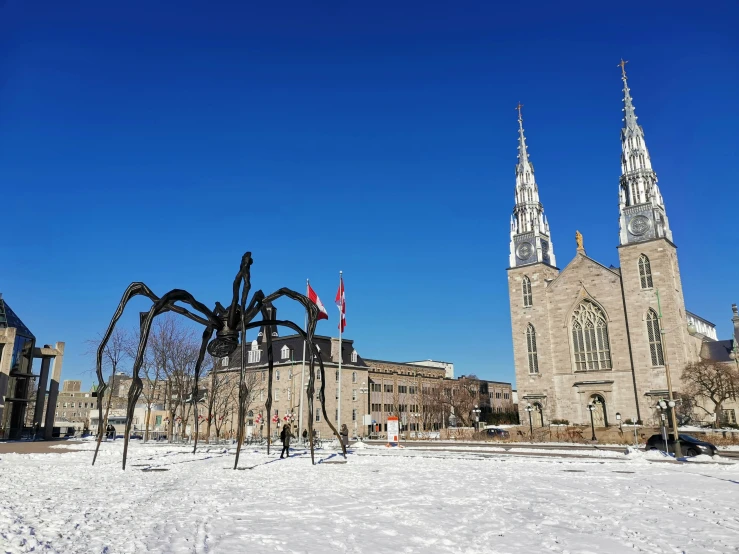 a huge spider sculpture in front of a cathedral