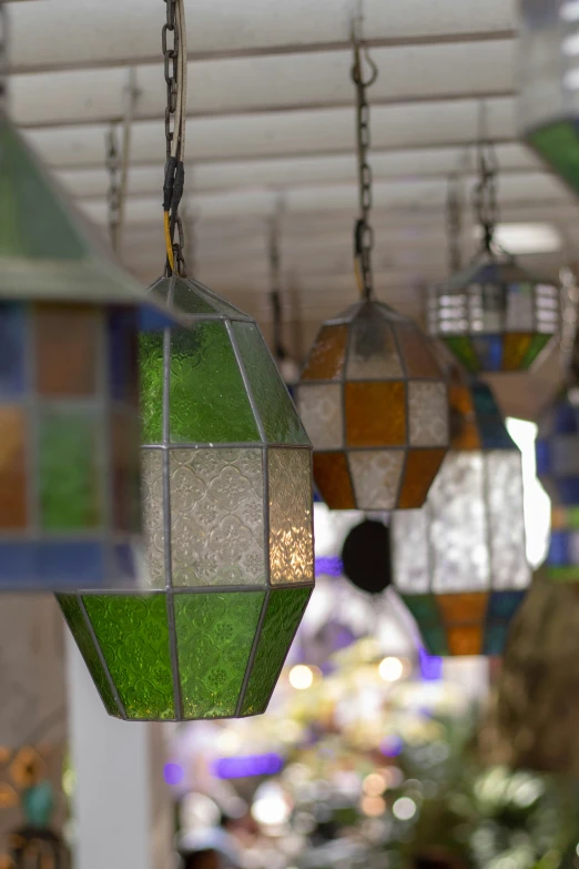 a collection of stained glass lanterns hang from chains