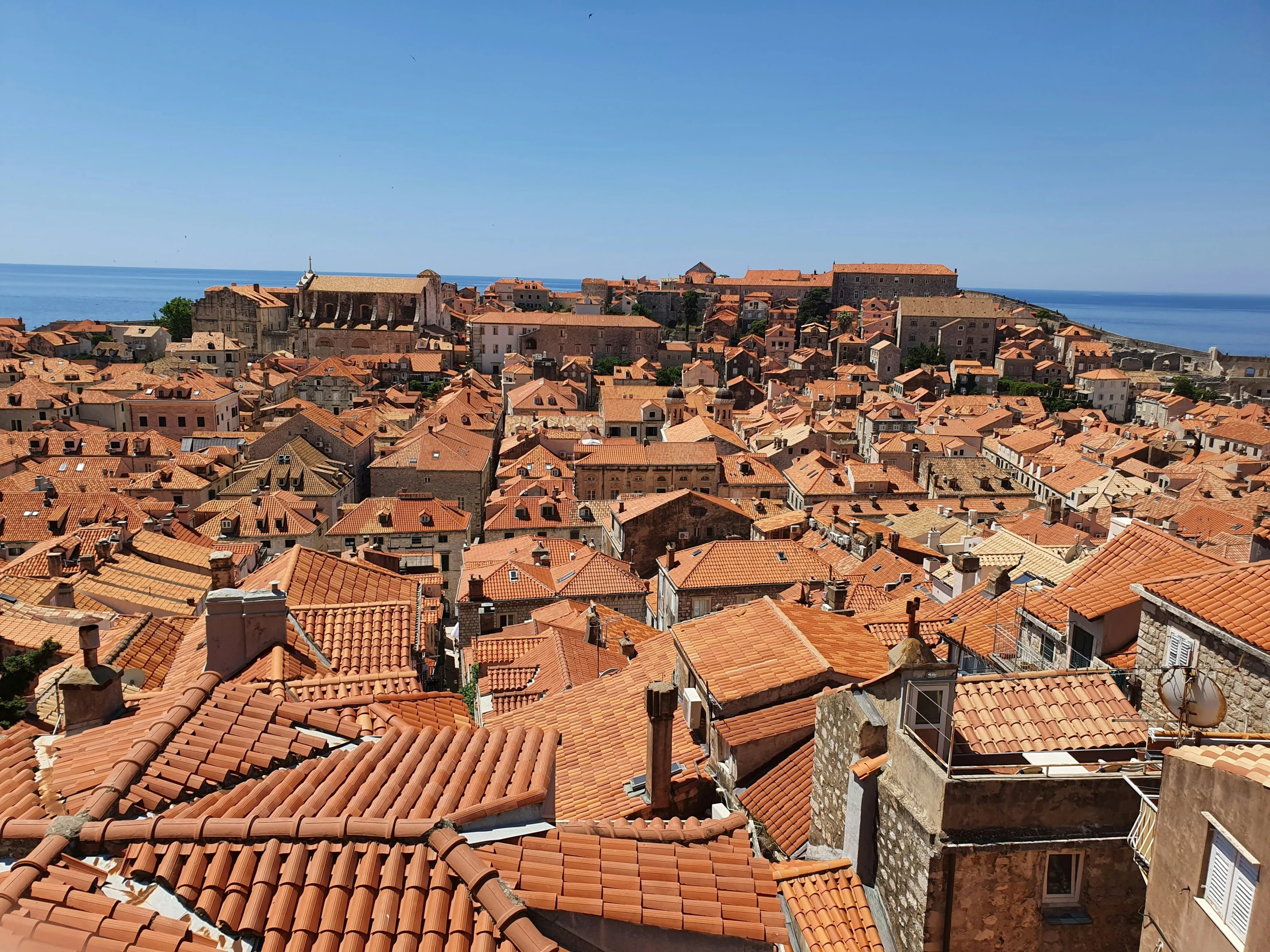 some very big buildings by the water with brown roofs