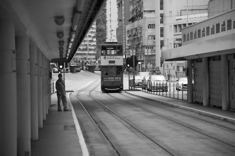 black and white image of a bus on train tracks