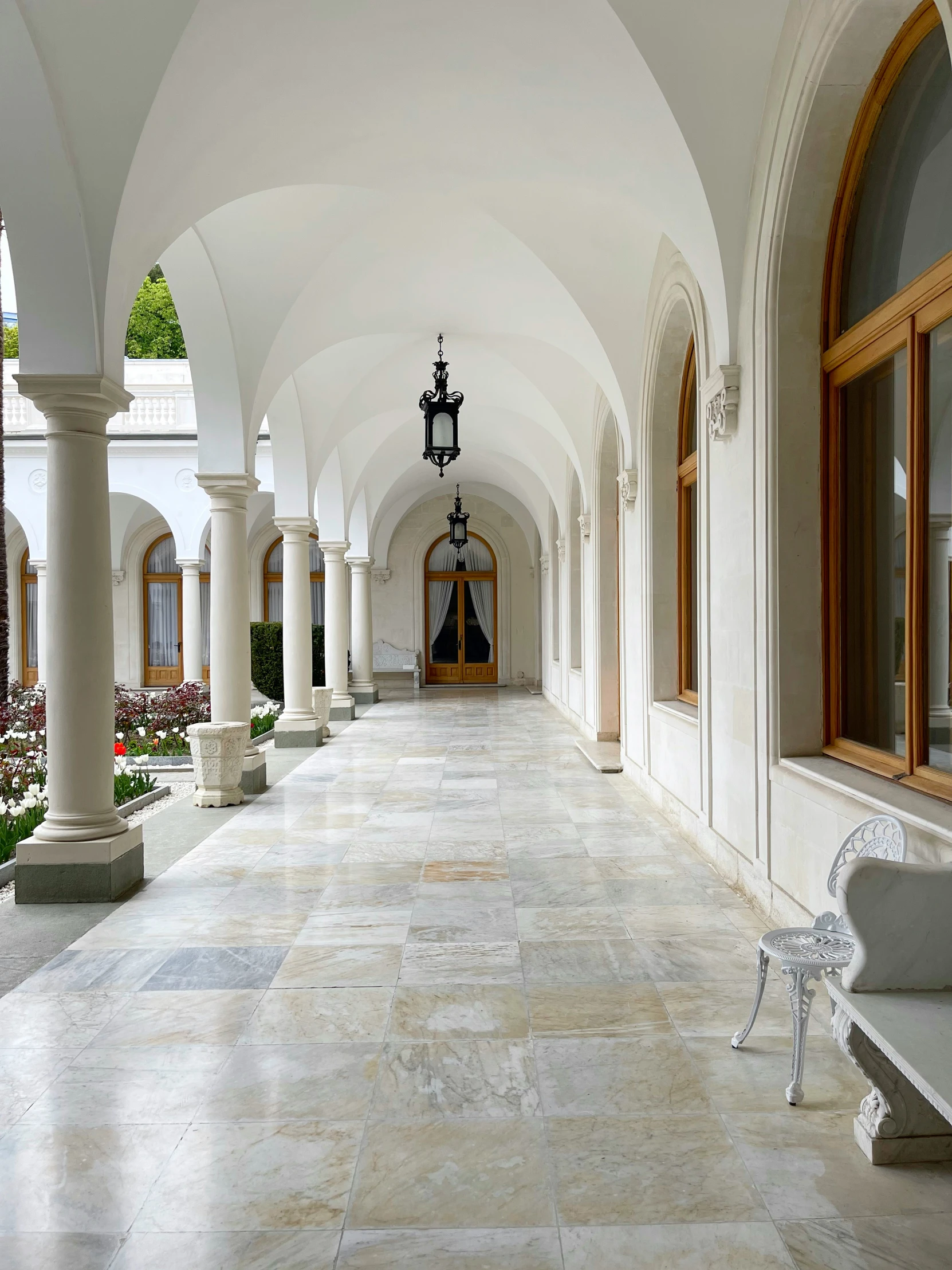 a hallway of large stone floors and arches