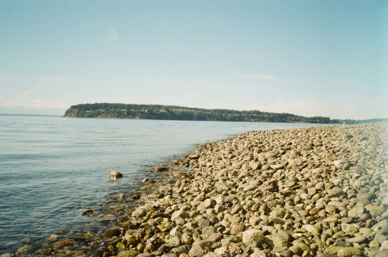 there are several rocks on the beach near water