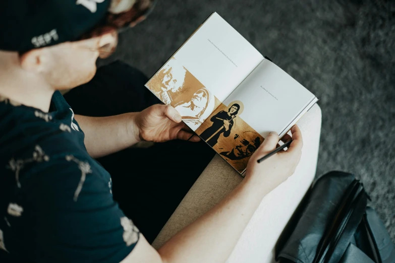 a person reads a book on the ground