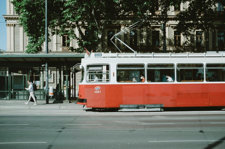 an old - fashioned streetcar traveling along the street