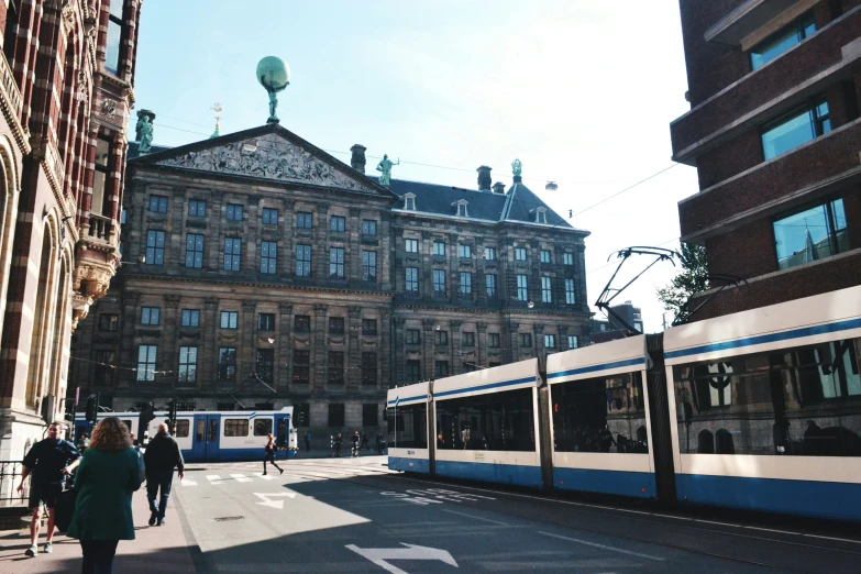 people walking on the street with a cable car next to buildings