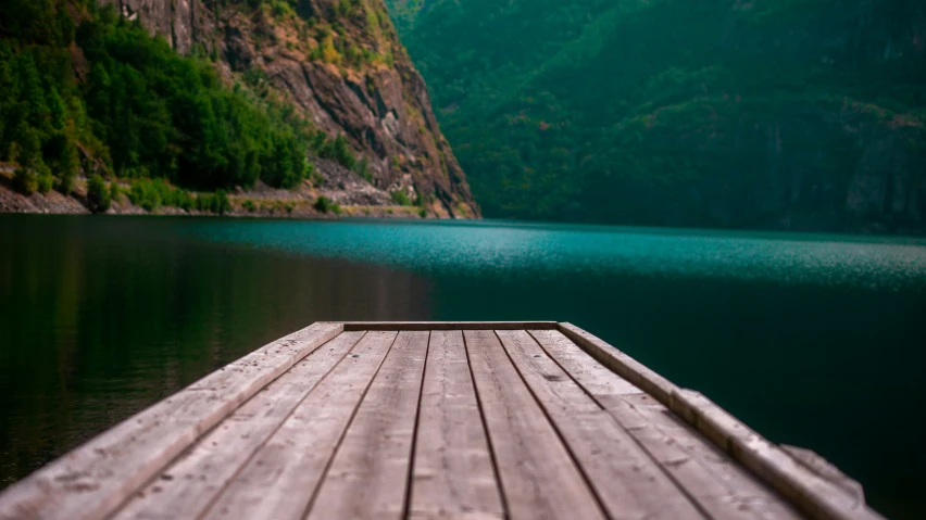 a dock with green mountains in the background