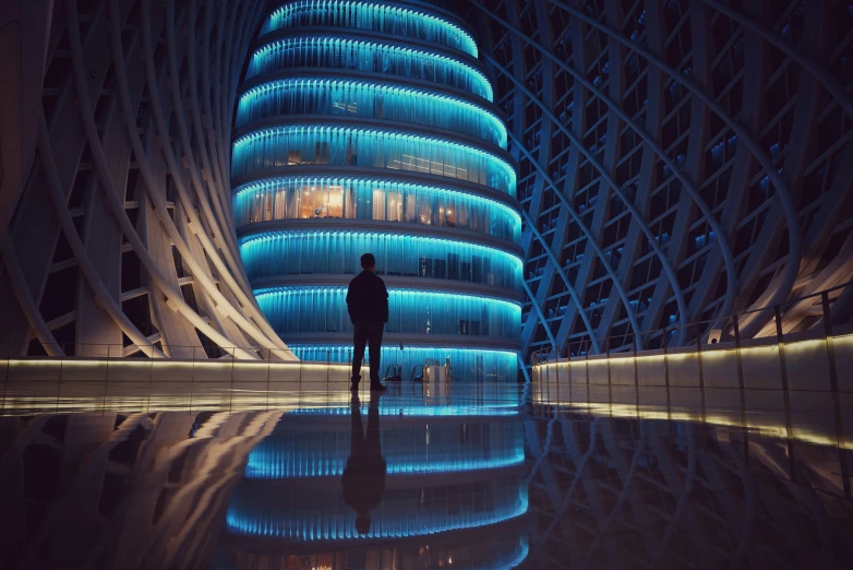 a man standing in front of the very big blue building