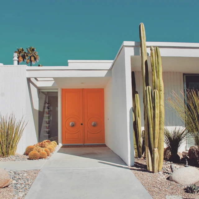 a small building with a couple of cactus and cacti outside