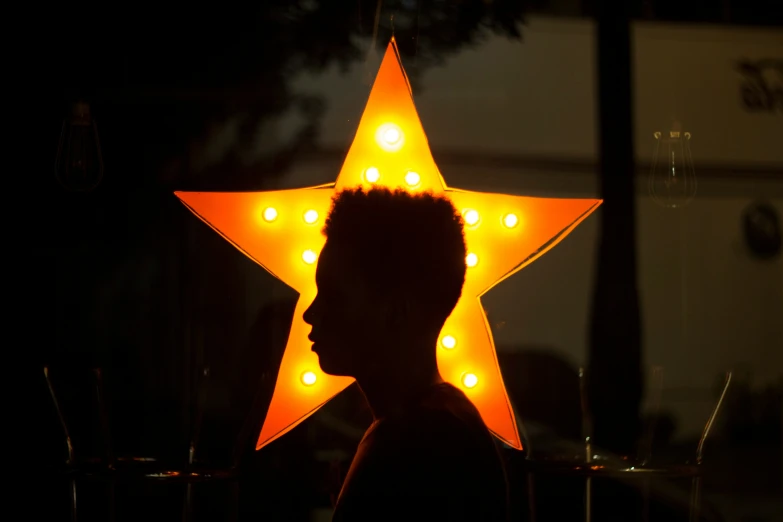 a person's silhouette is in front of a lighted star