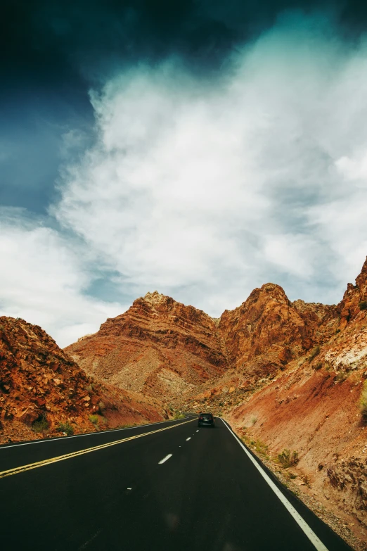 a car is driving on the highway through the mountains