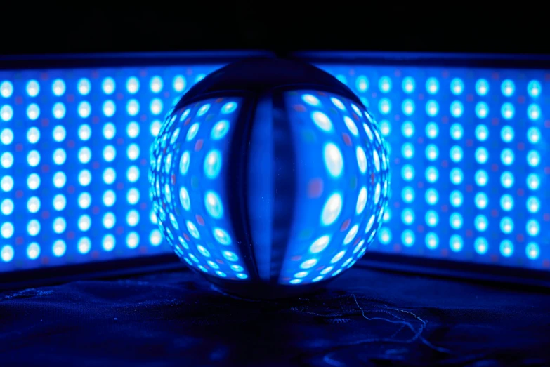a blue light ball sitting in the dark