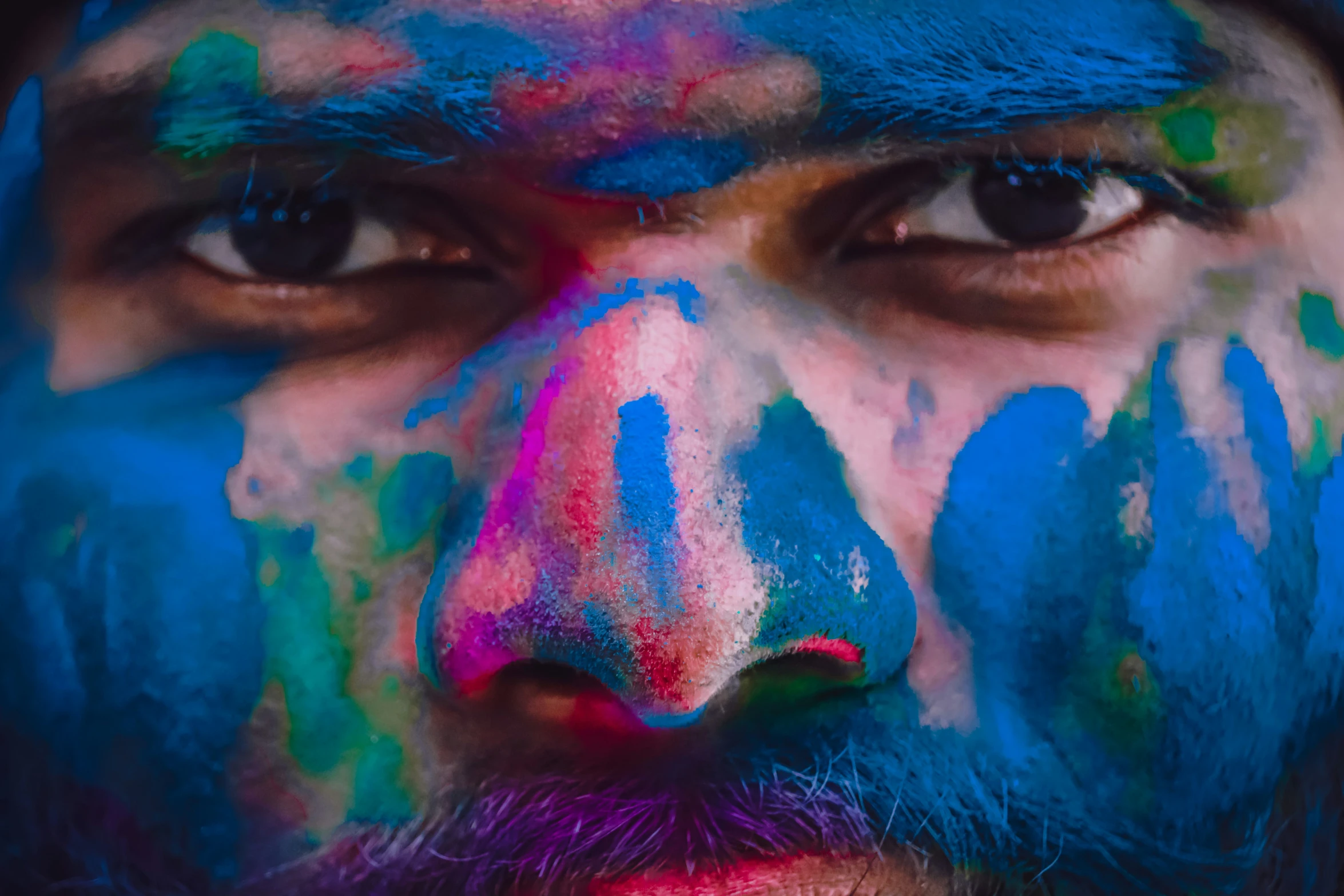 a man with colored face paint painted all over his face