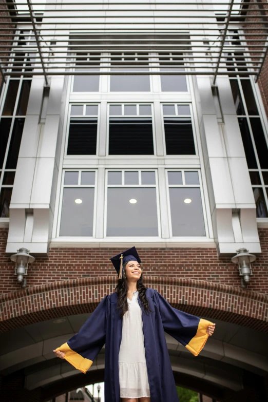 a smiling female graduate standing on the stairs