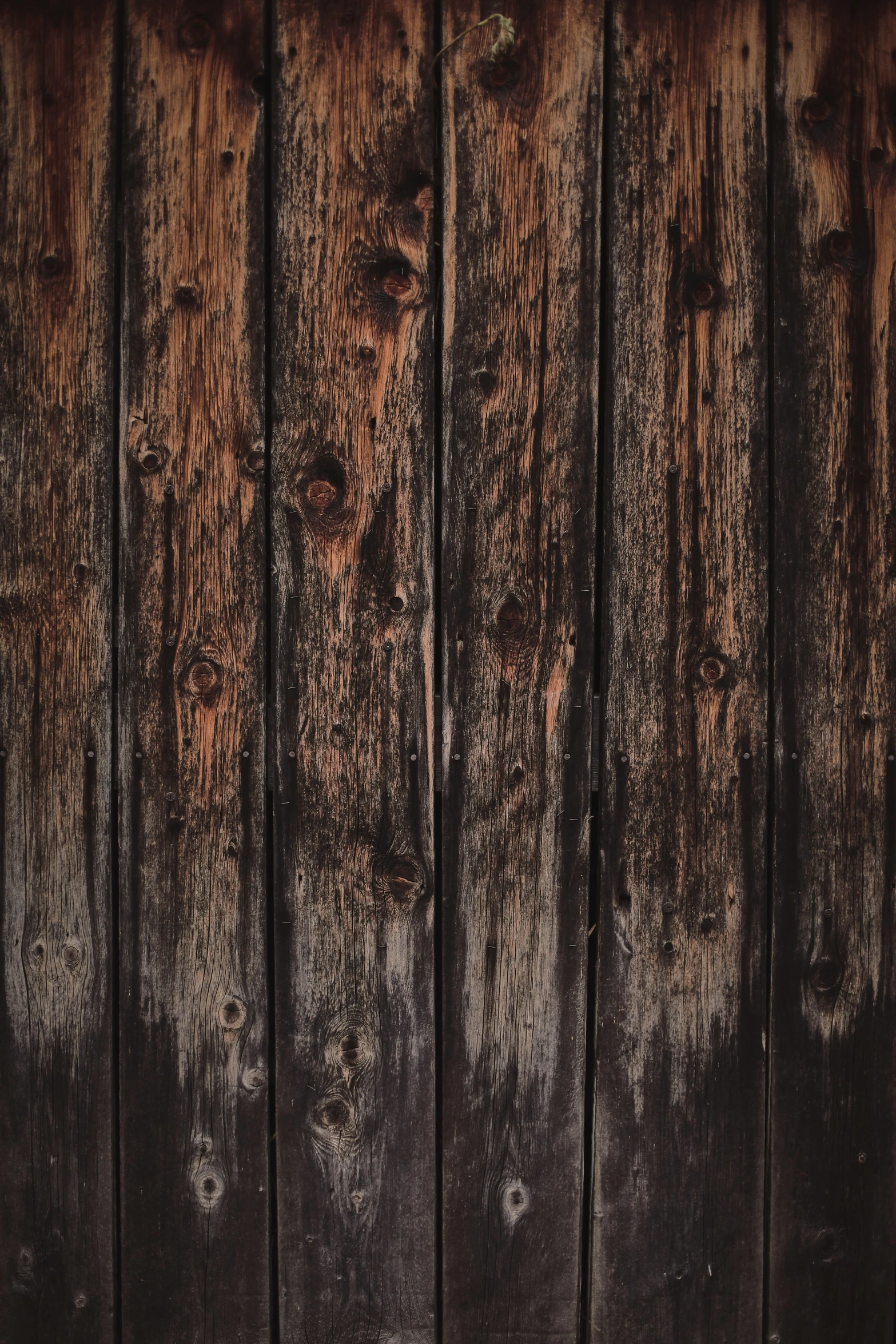 a dark wooden wall that has been weathered and chipped