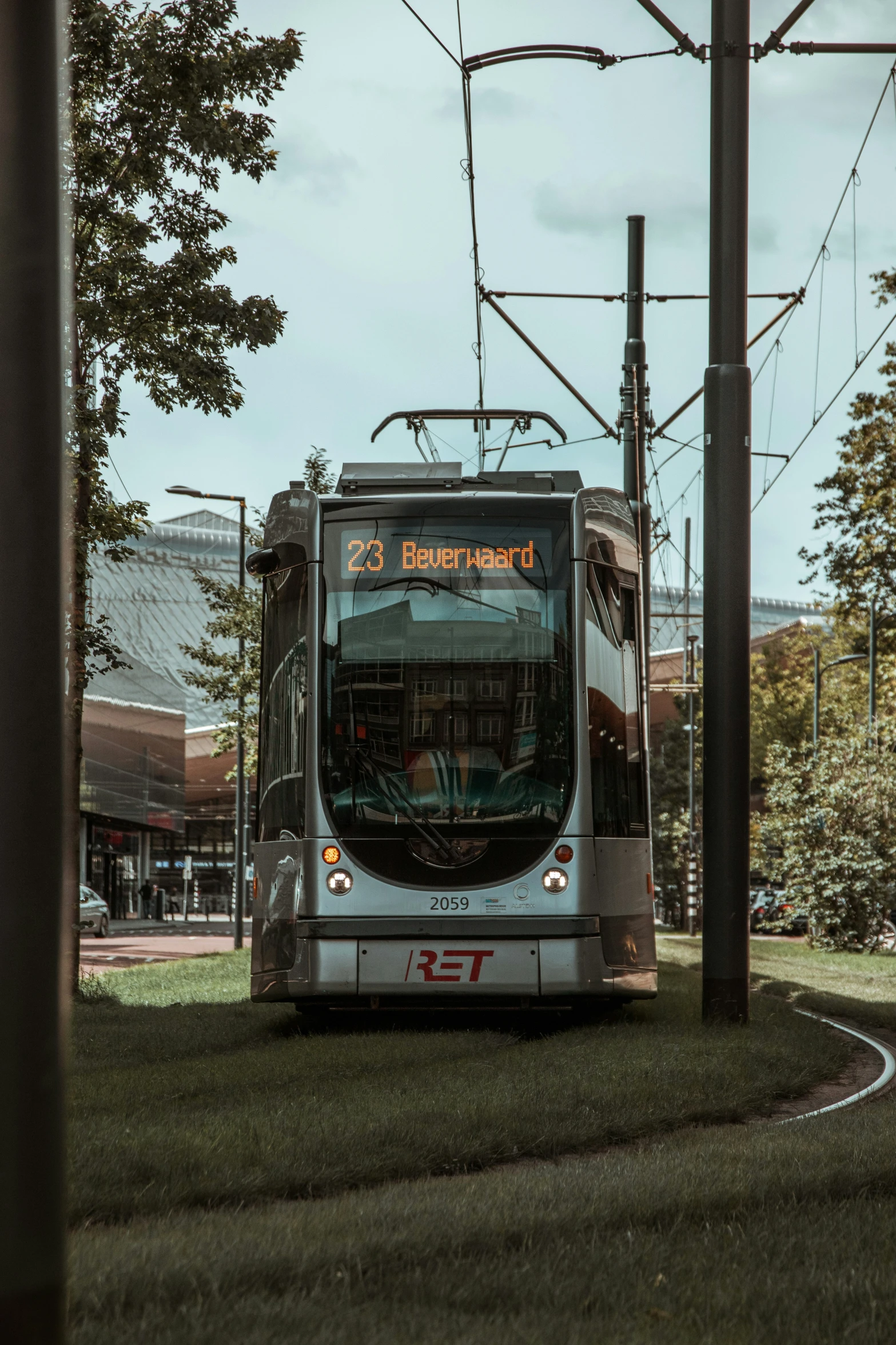 a passenger bus travelling down a street near power lines