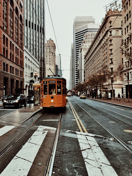 a trolley is on the tracks of a city street