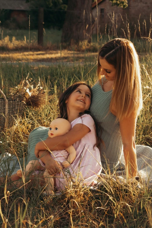 two young women hugging while laying in grass