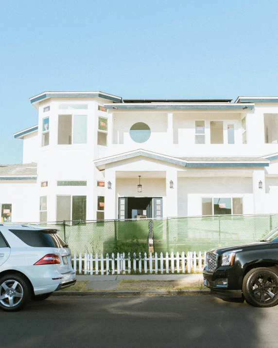 cars parked in front of a large white building