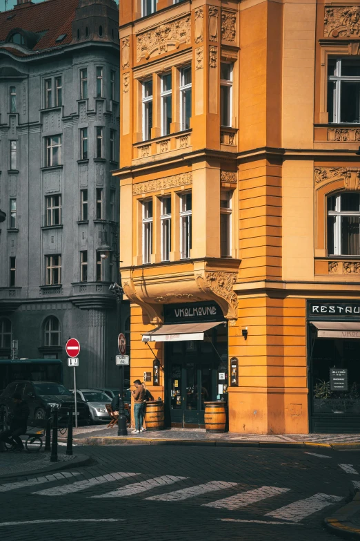 a tall yellow building sitting next to two brown buildings