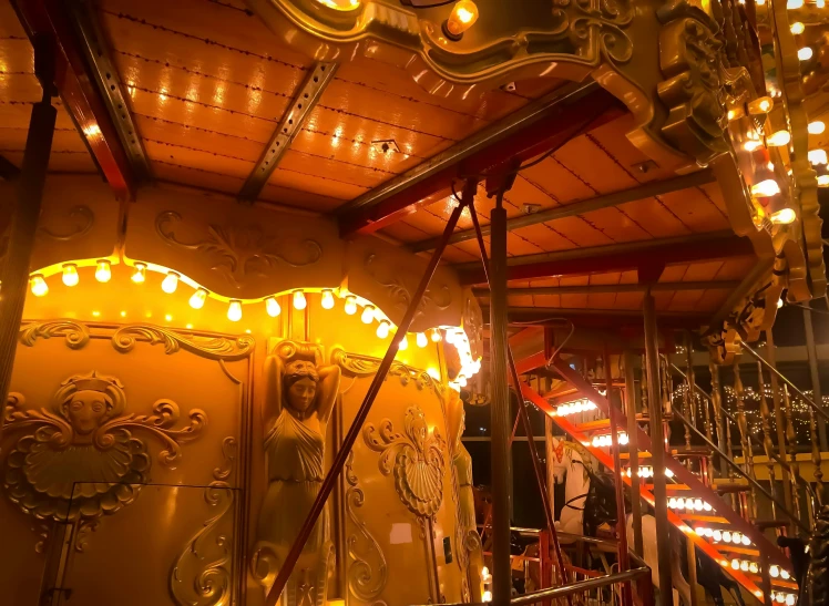 a very fancyly decorated carousel with lights around the horses