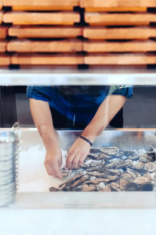 a person standing behind a counter preparing food