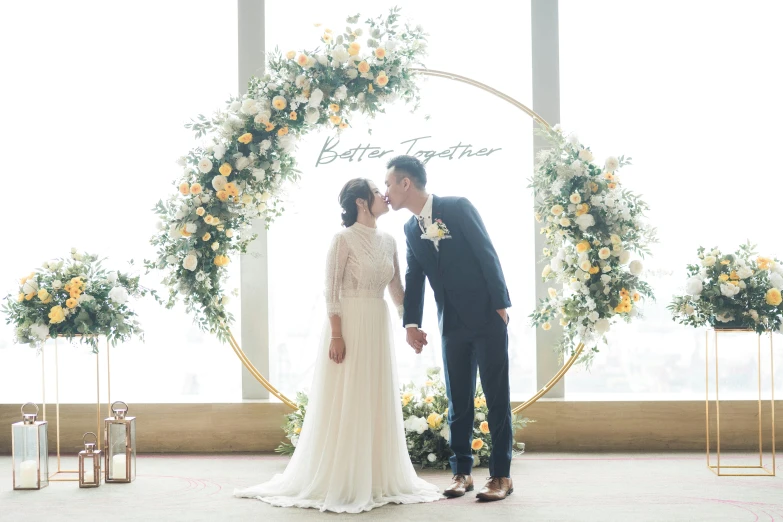 a bride and groom standing by the wedding arch