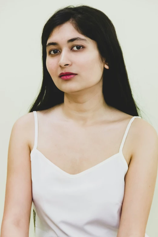 a woman is looking straight ahead wearing a white top