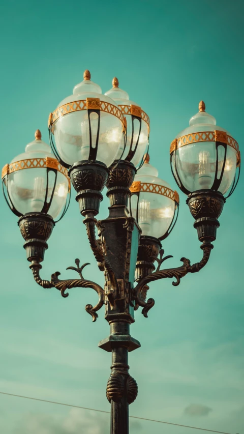 a three lamp pole has white glass ornaments on it