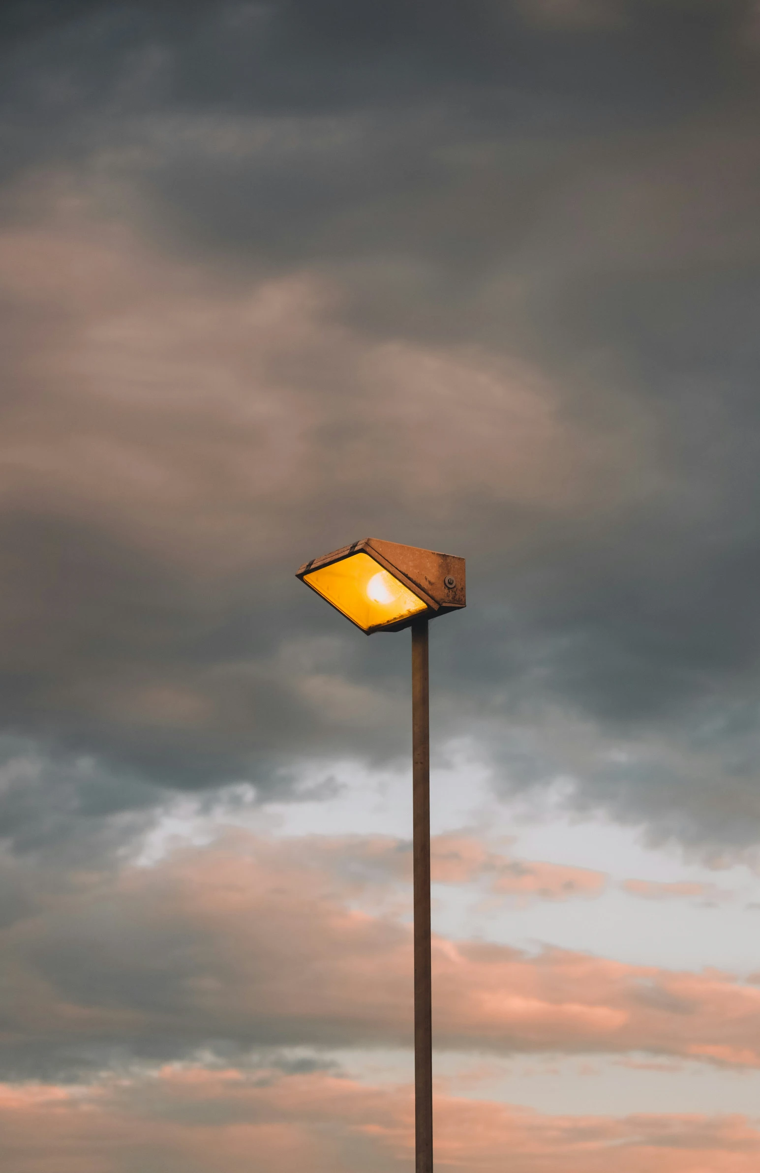 a street light in the middle of a cloudy sky