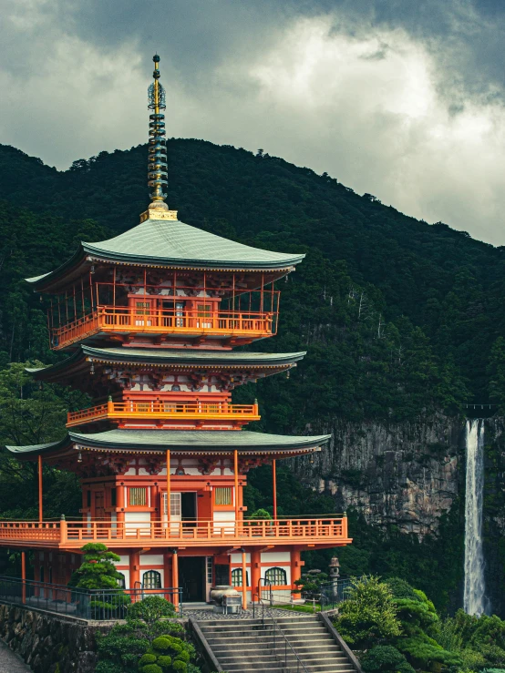 a building with four levels in front of some mountains