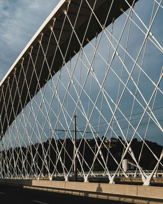 a bridge with wires and a blue sky behind