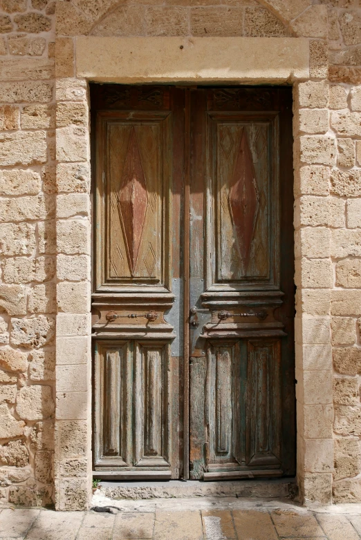 the large wooden door to the building has a nice pattern on it