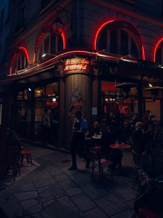 people sitting at tables in an outside cafe