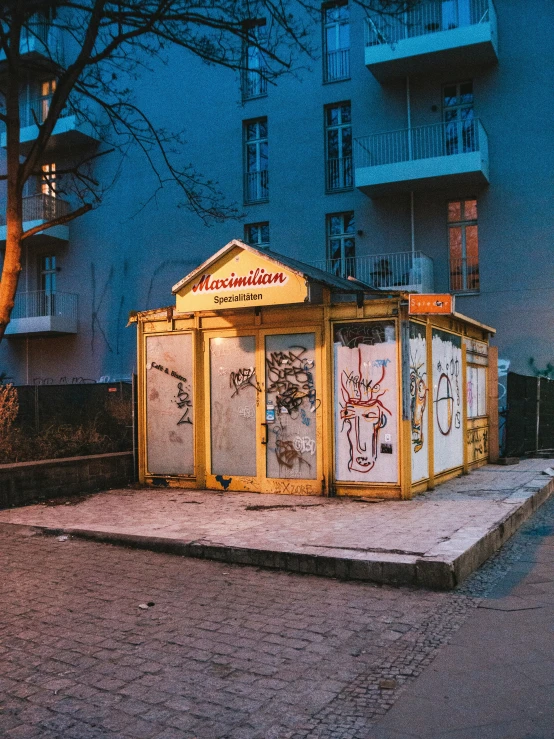 small outdoor booth with graffiti on the windows