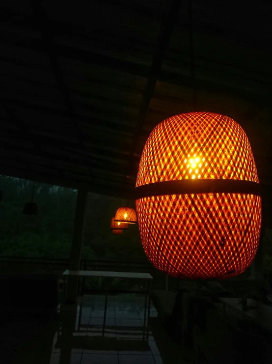 a large red light on a pole with strings