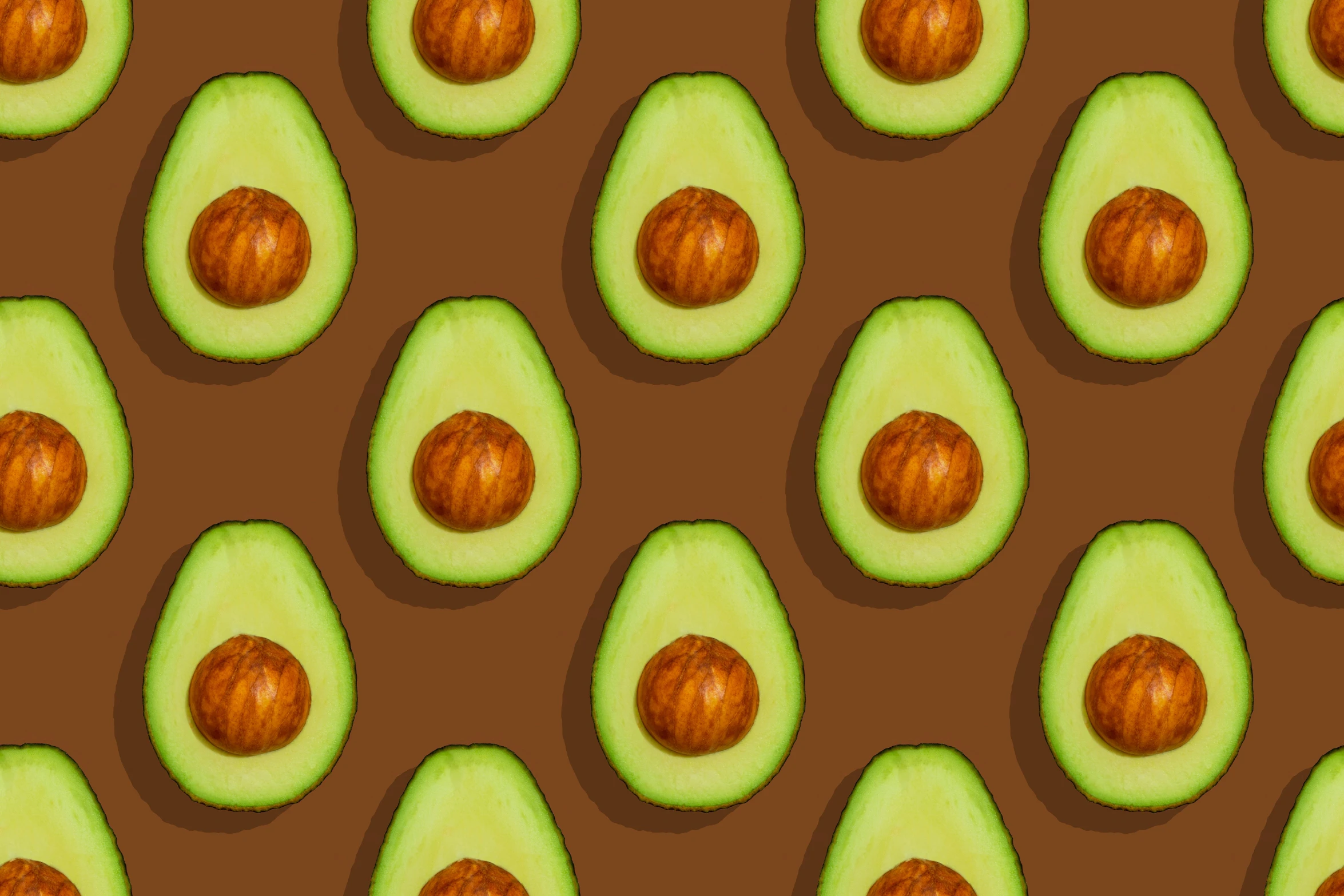 several avocados are arranged on brown ground