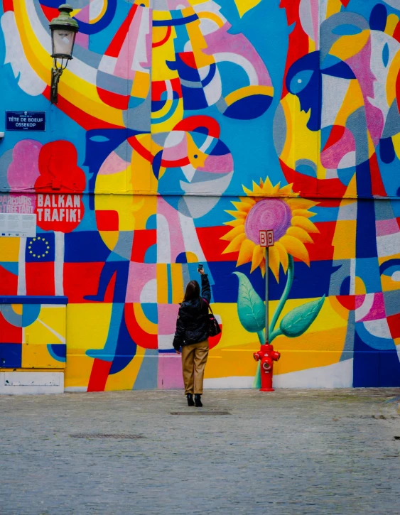 a person standing in front of a brightly painted wall