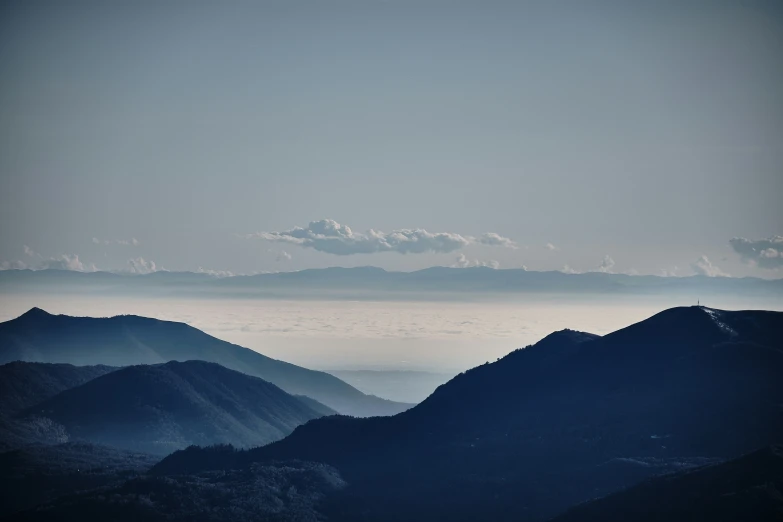 a distant mountain range with low lying cloud