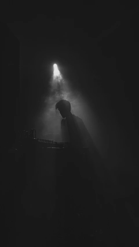 a man sitting at a turntable in the dark