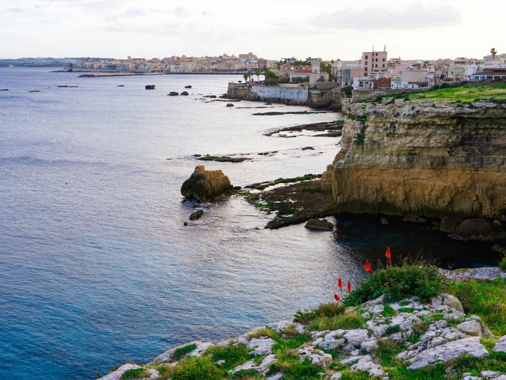 houses and buildings sit on the cliff overlooking the ocean