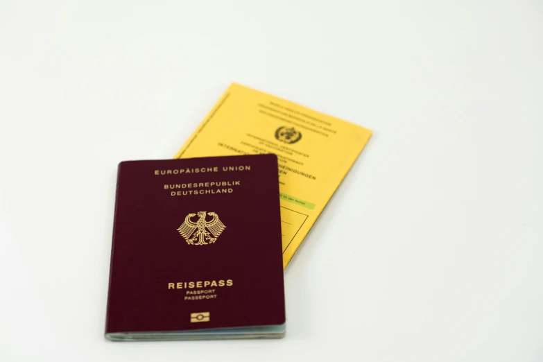 two small passports are on a white table