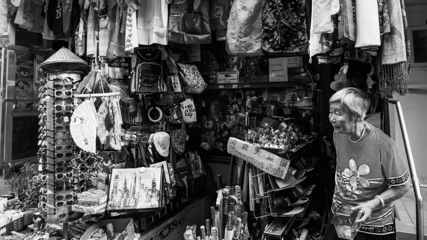 a woman looks at items in an outdoor market