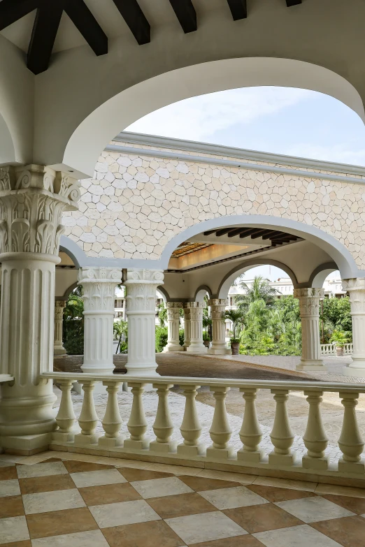 an archway with columns, checkered tiles and a fountain