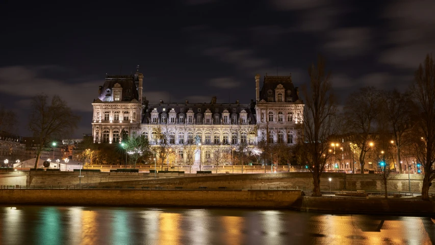 a river at night with a boat in front of a building