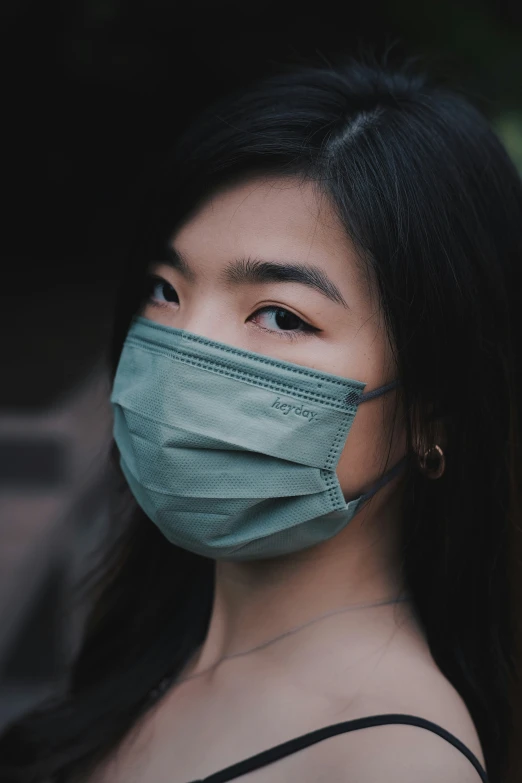 an asian woman wearing a surgical mask