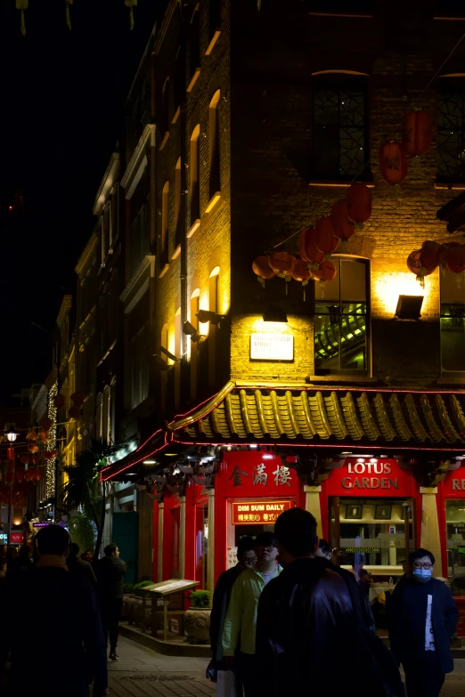 people are walking down the streets in the city at night