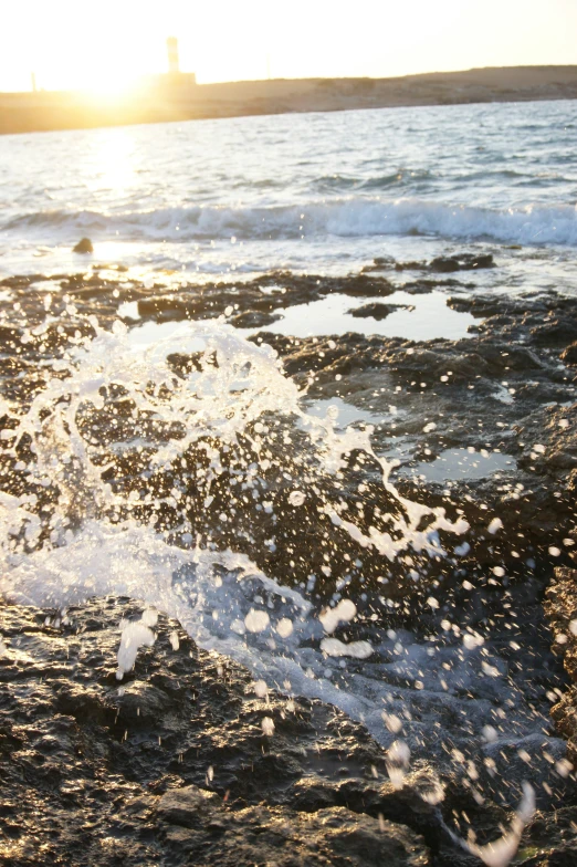 water splashes on the rock face of an ocean beach