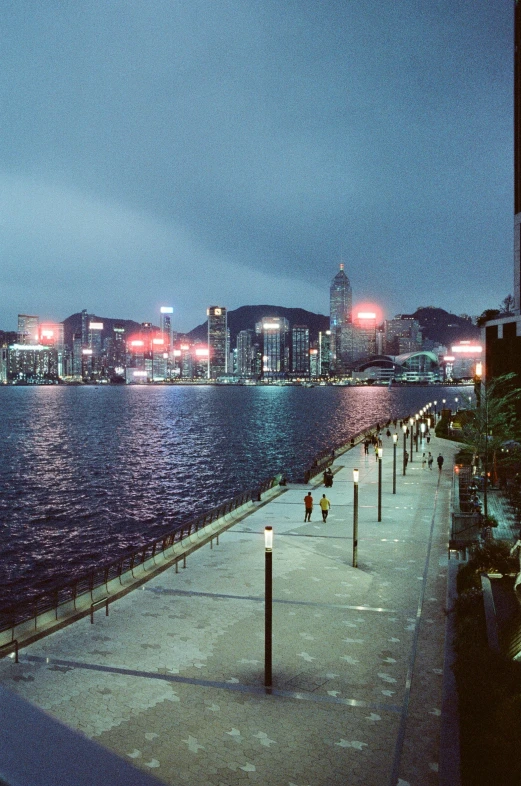 an empty sidewalk in front of a large body of water