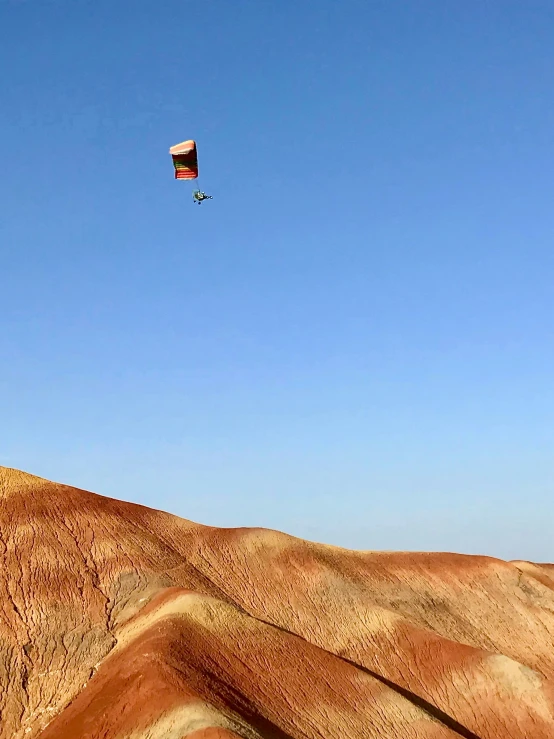 a person riding down a hill with a parachute