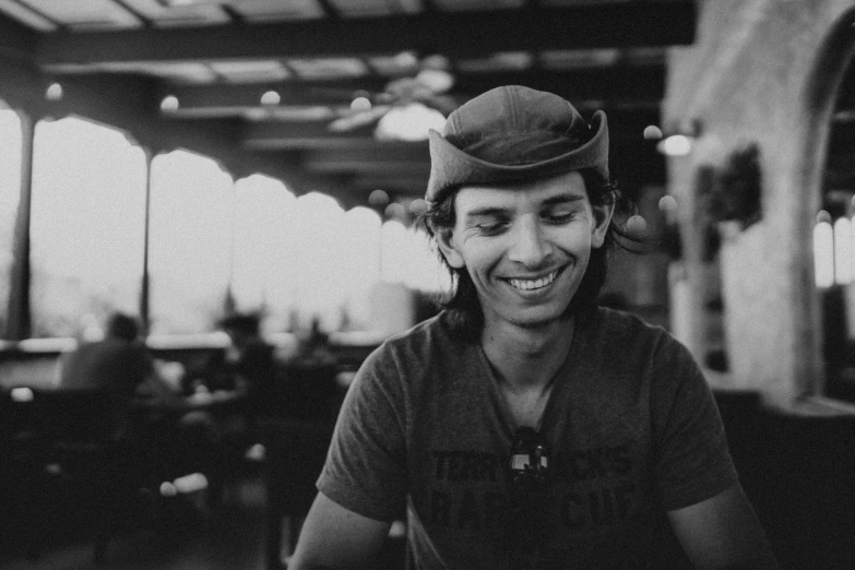 man in the cap sitting at a table laughing